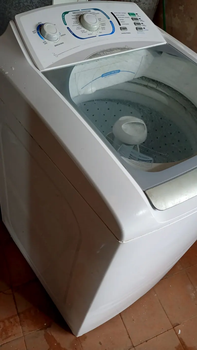 Lavadora Electrolux branca, vista de cima e de lado, com a tampa de vidro